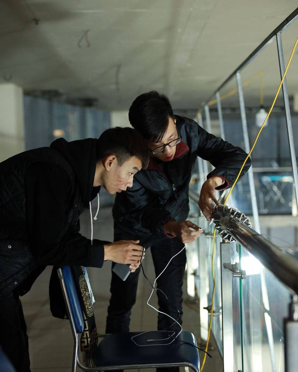 Two engineers working together on a cable run, terminating and testing on site